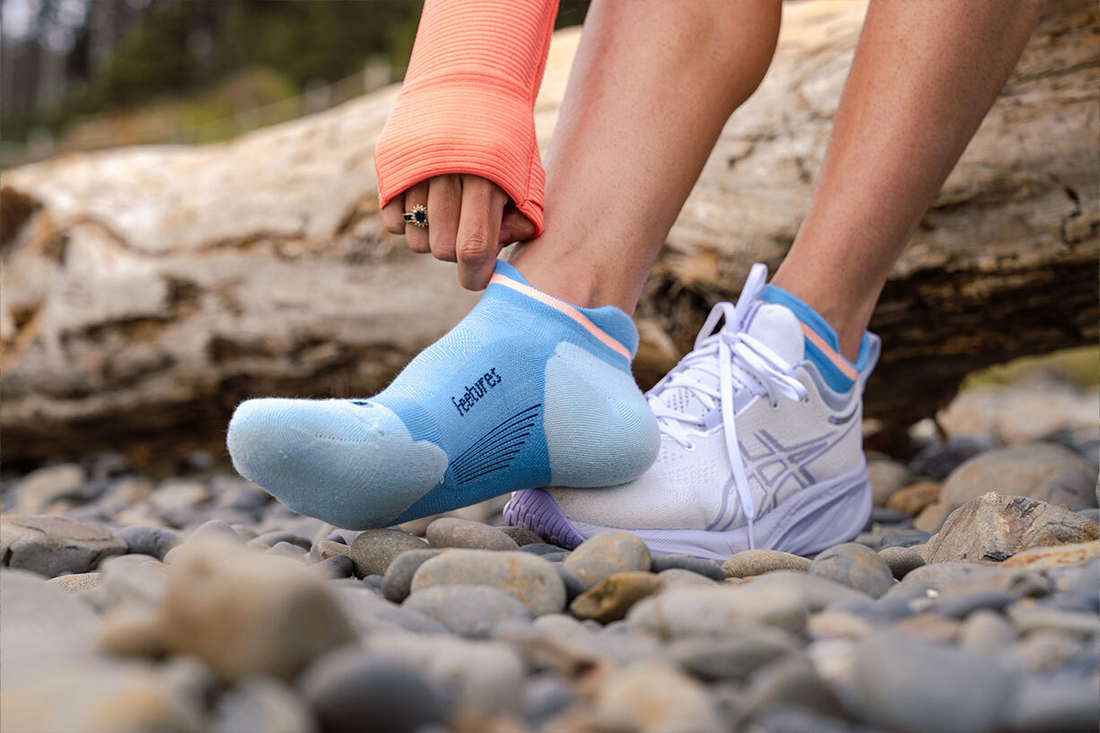 Woman pulling on a pair of Feetures socks